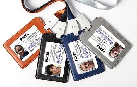 Four press passes with pictures and info with brown, black, blue and gray holders and lanyards