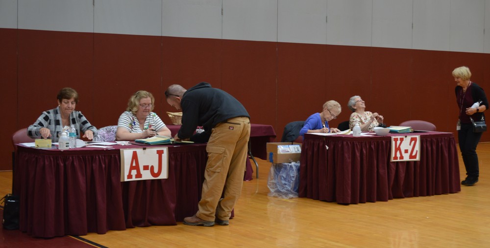 A man votes at two tables in Livingston Manor