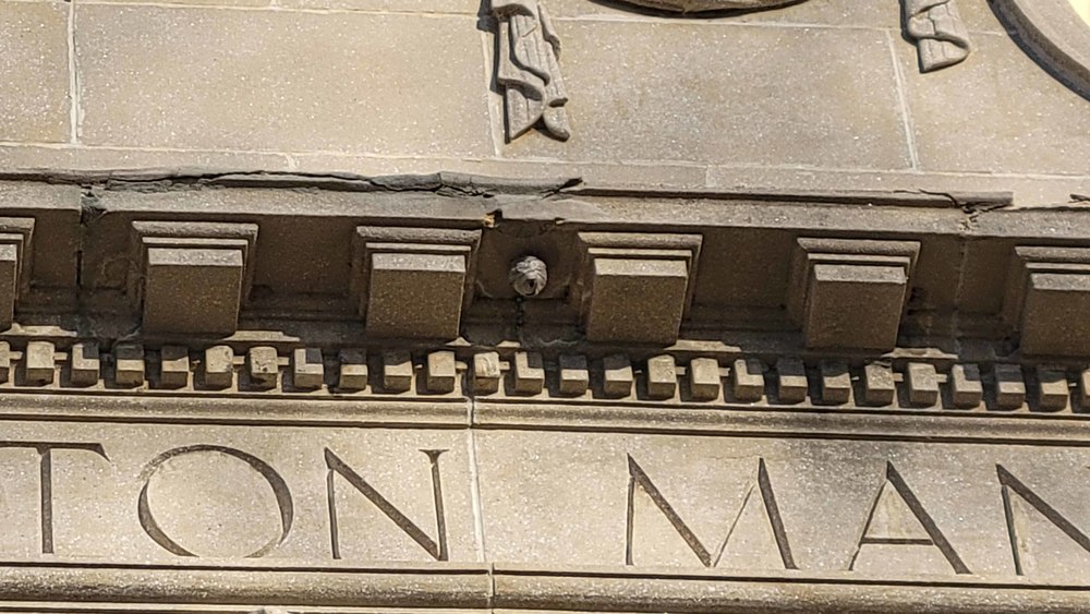 Crumbling masonry is seen on a facade
