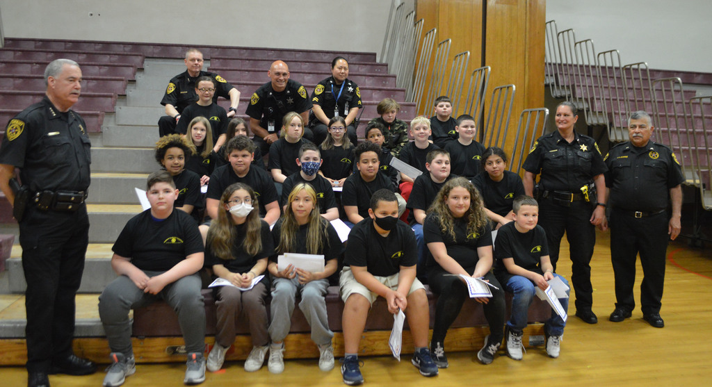 DARE students and officers pose for a photo on bleachers