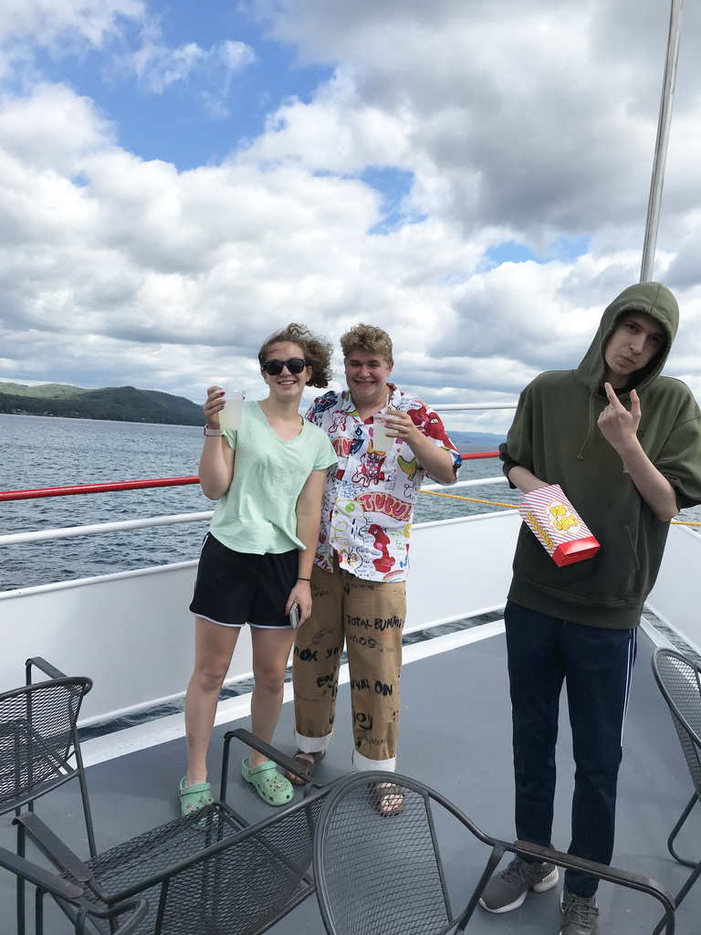 Three people pose on a boat