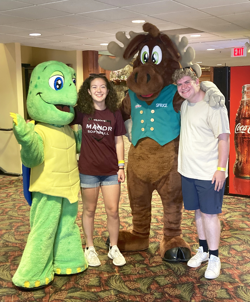 Two people pose with people dressed as a turtle and a moose