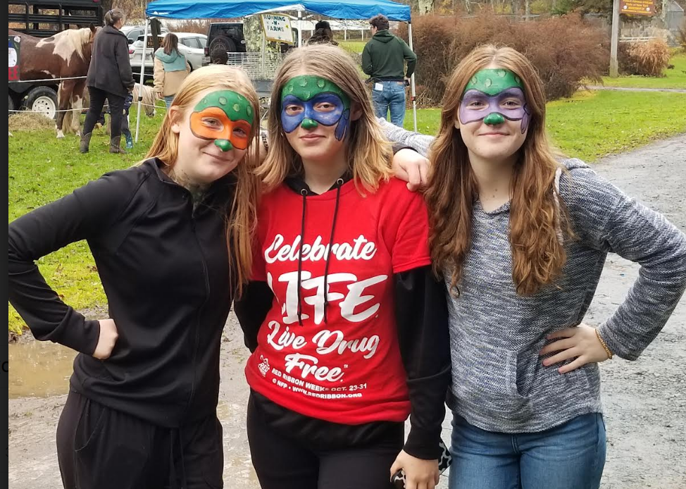 Three people post with their faces painted