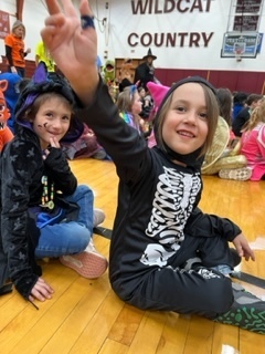 A student in a skeleton costume waves next to a vanpire