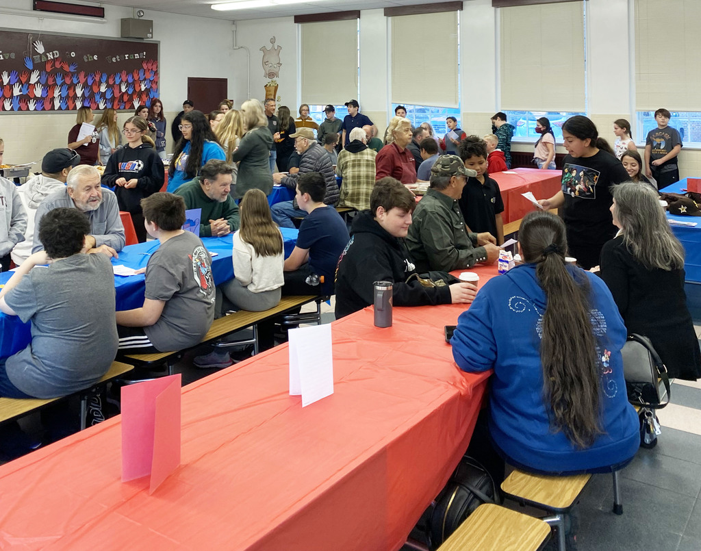 People sit at red and blue topped tables