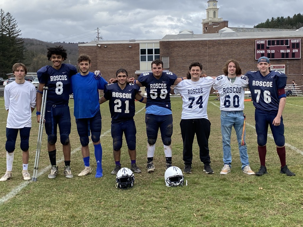 Eight football players pose for a photo.