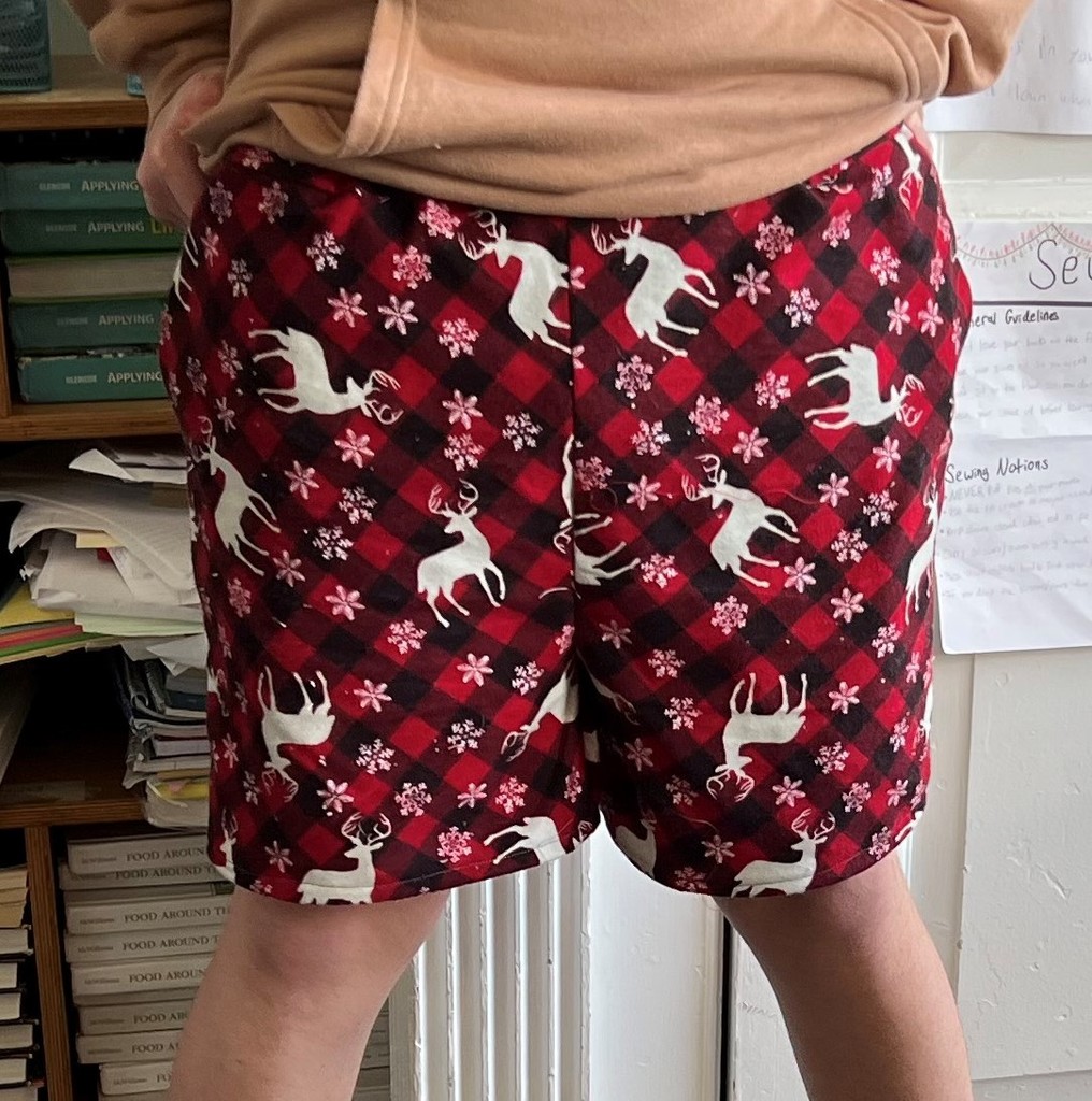 a  student models red and black pj shorts with white deer on them