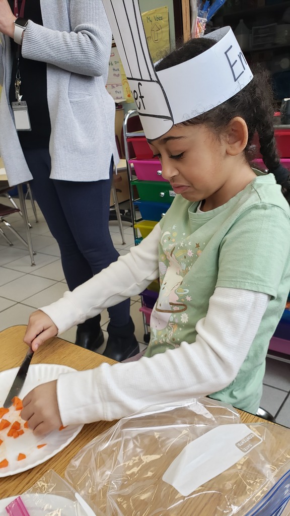 A student uses a plastic knife cuts ingredients