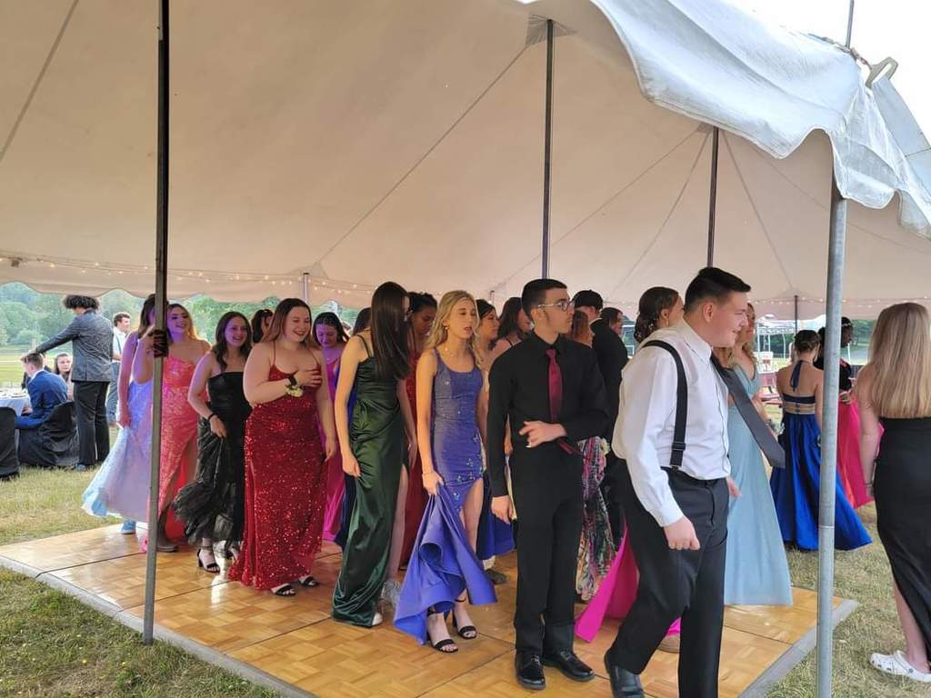 Students dance under a tent on a portable dance floor.