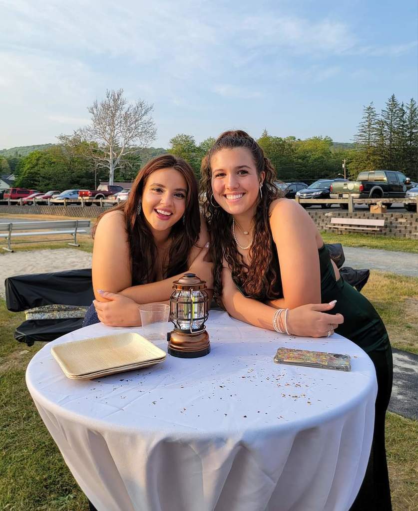 Two students pose for a photo at a table