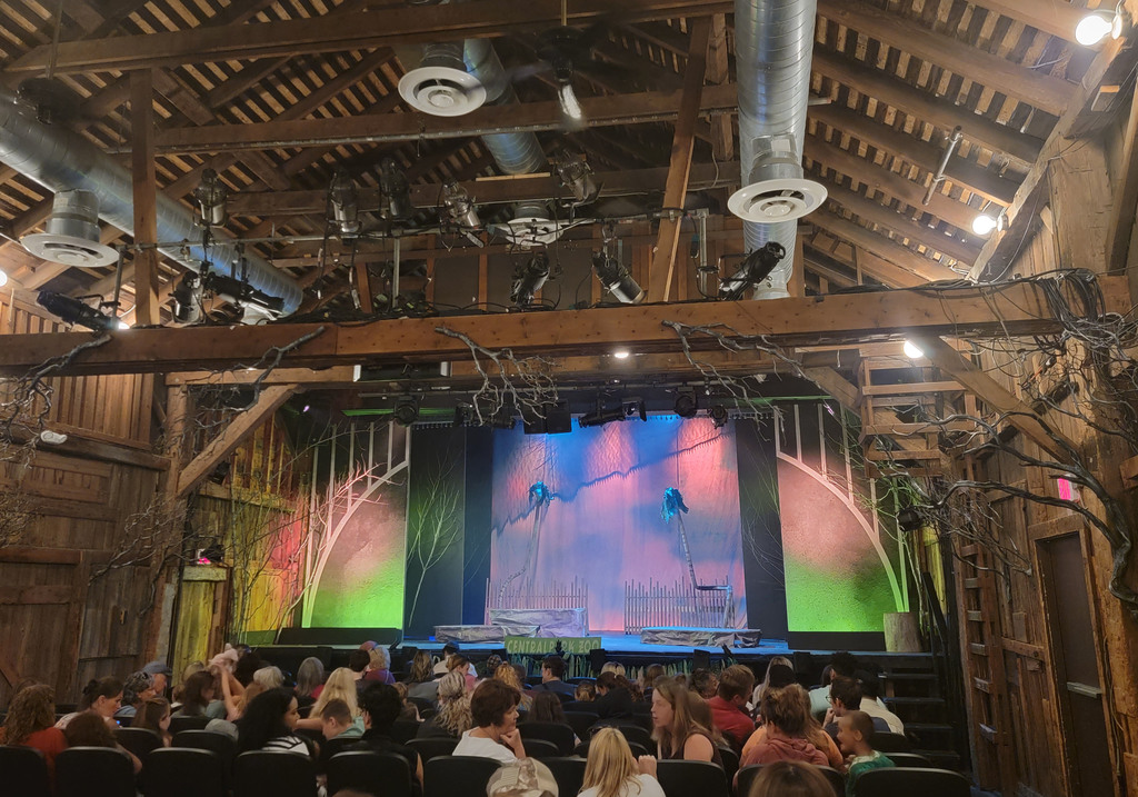 A colorful backdrop is on a stage  of a theater with wooden accents