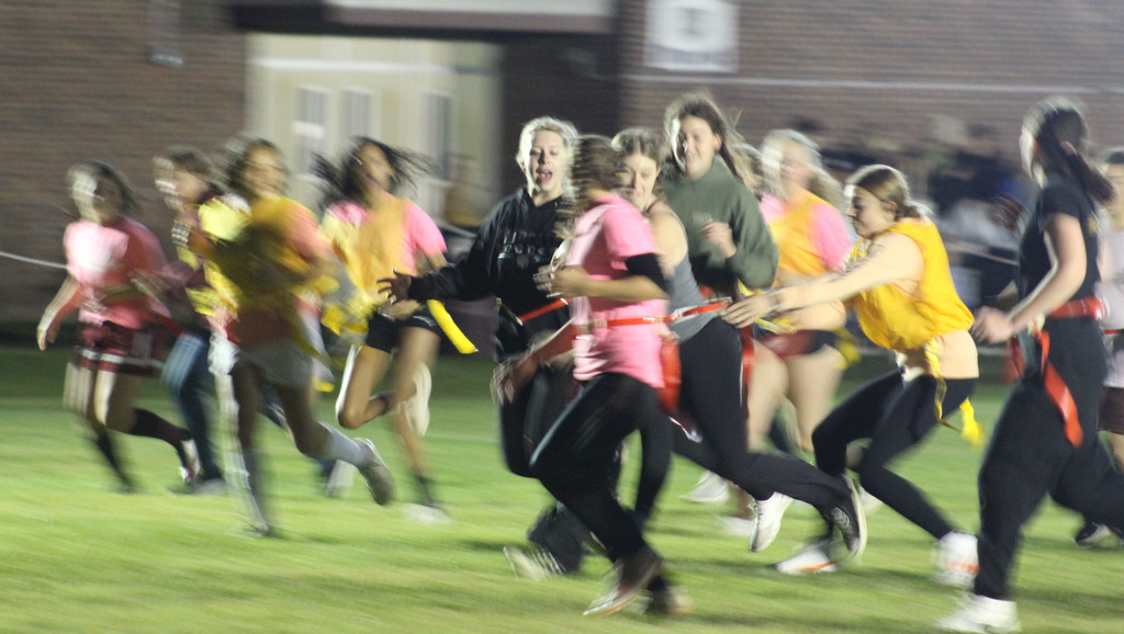 A student grabs the flag of another student as others surround them during a game